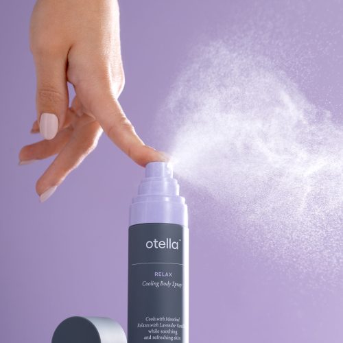 finger spraying a bottle, purple background